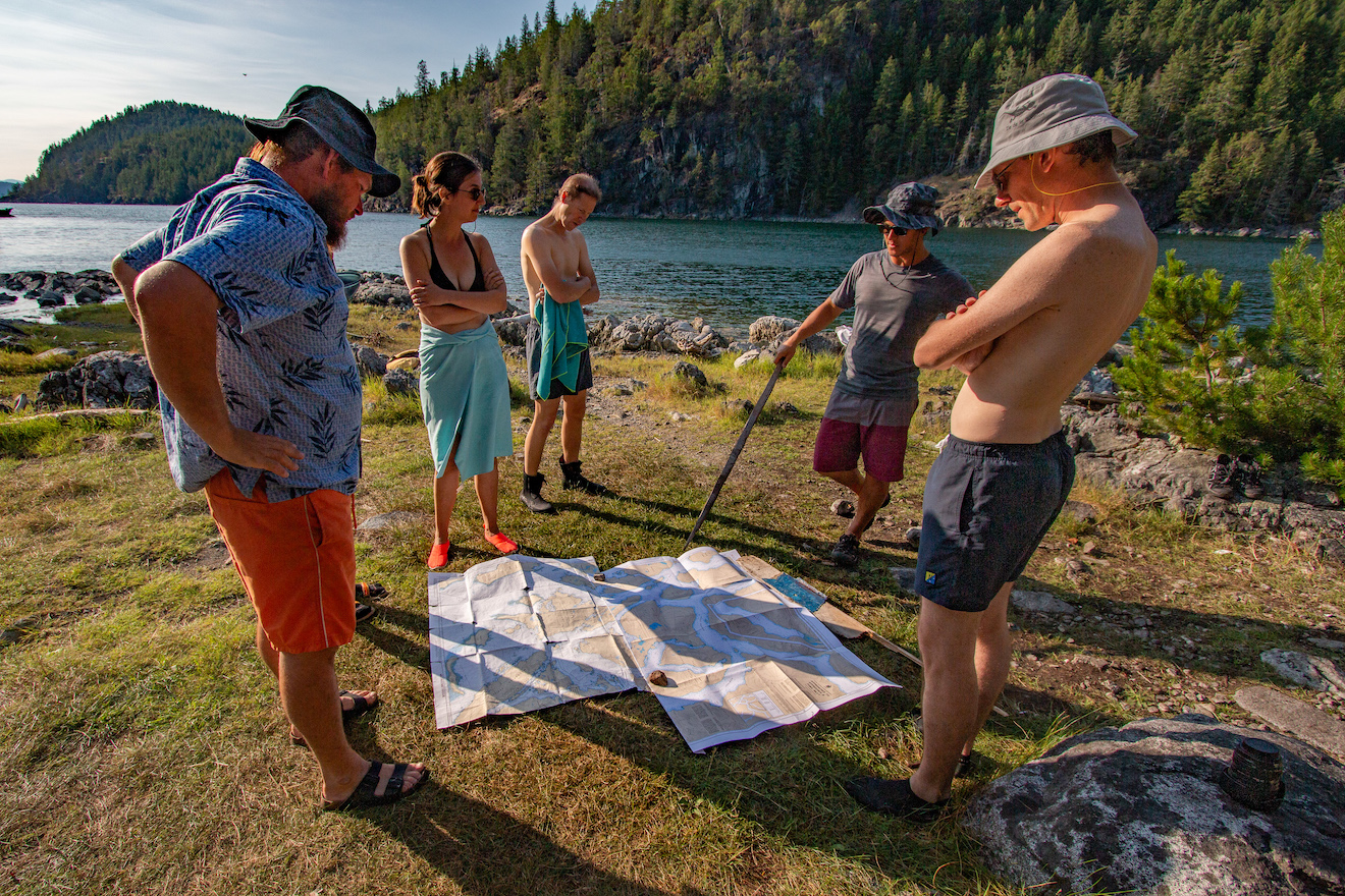 Guides and guests looking at charts in Desolation Sound